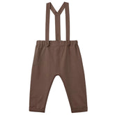 Brown children's overalls with suspenders on a light gray background