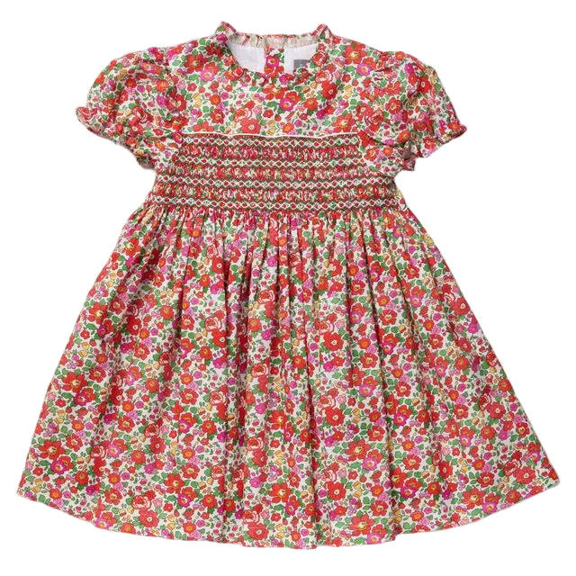 A toddler girl's short-sleeve dress with a vibrant red, pink, and green floral print, featuring a smocked bodice and puffed sleeves, laid flat on a light gray background.