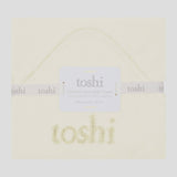 Folded baby blanket with 'toshi' branding on a white background