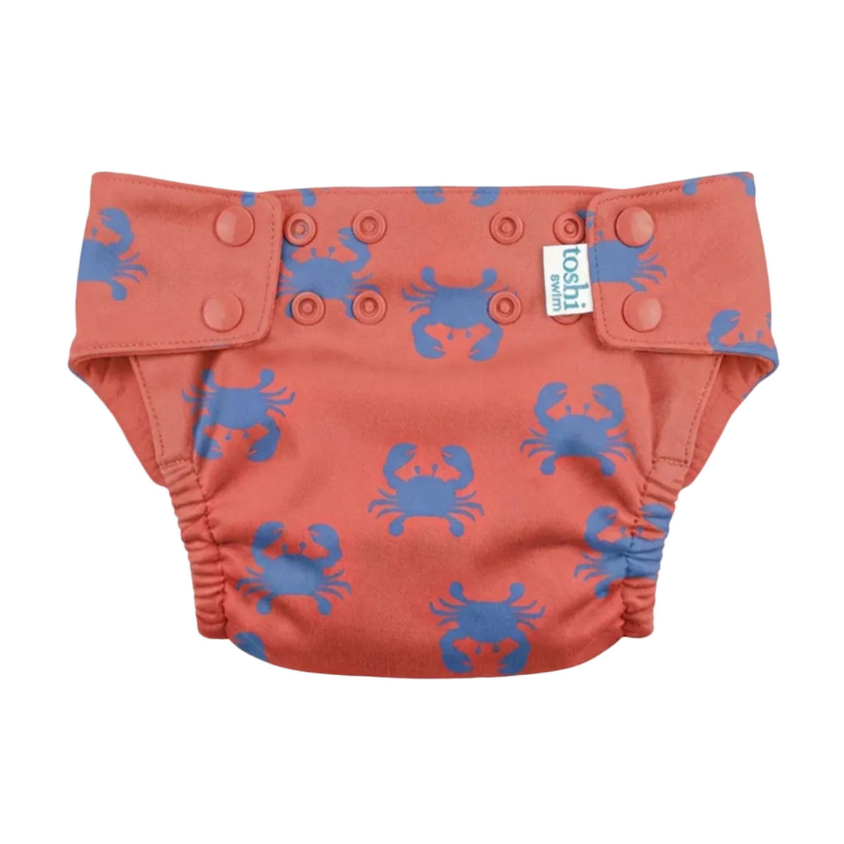 A coral orange reusable cloth diaper with a blue crab pattern, featuring three adjustable snap closures on the front and a small white 'nuna' brand tag.