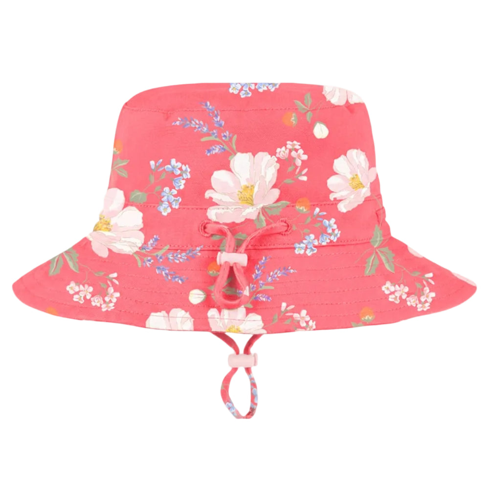 A girls pink wide-brim sun hat with a floral print featuring white, pink, and blue flowers with green leaves, complete with a matching chin strap.