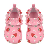 A pair of pink baby mule style swim shoes with a strawberry and white flower print, featuring ruffled trim around the open back and pull tabs, shown on a light gray background.