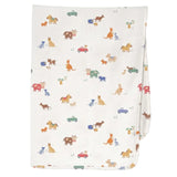 A folded white muslin blanket featuring a colorful cartoon animal print of dogs, cats, kangaroos, and small cars, shown against a light gray background.