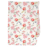 A folded baby blanket or swaddle featuring a delicate Australina floral pattern with pink, red, and blue flowers on a warm cream background, shown against a light gray studio backdrop.