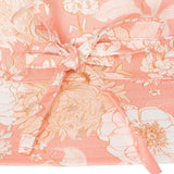 Floral hat closeup of the bow tie with pink and white flowers on a light pink background