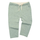 Green knitted pants with a drawstring on a light gray background