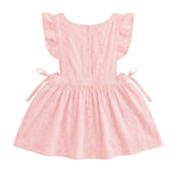 A light pink baby dress with ruffled cap sleeves, a buttoned back, and side ties, shown against a plain light gray background.
