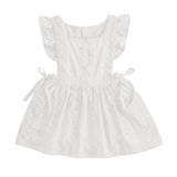 A white sleeveless baby dress with ruffled cap sleeves, a square neckline, embroidered details, and side ties, shown against a light gray background.