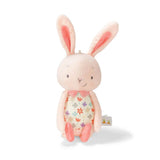A soft pink plush toy in the shape of a bunny with floral patterned body and embroidered facial detailing.