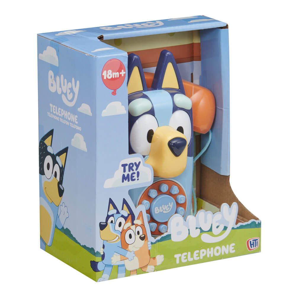 Bluey Bluey Telephone toy in its original retail packaging, featuring a light blue dog-shaped telephone with a yellow snout, blue ears, and an orange telephone receiver in the background.