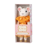 Plush toy mouse in a box with 'Claris' branding on a white background. The doll is wearing a tangerine coloured dress
