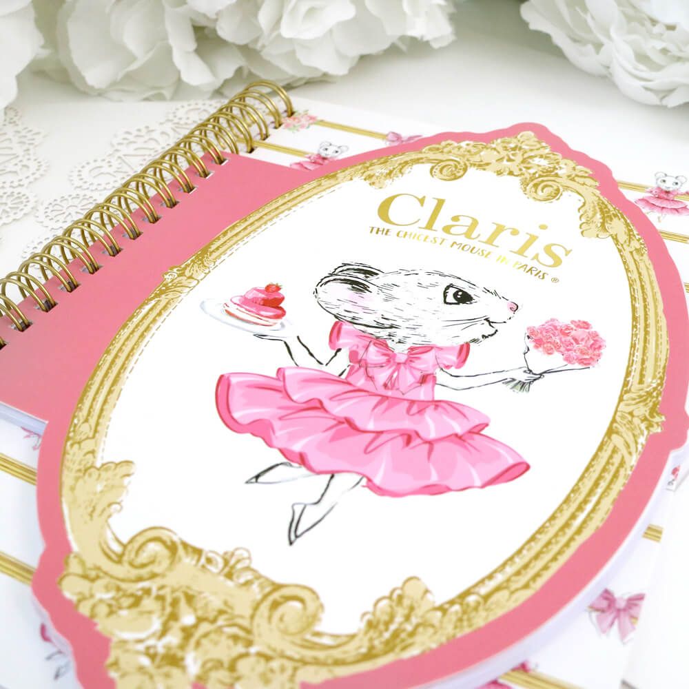 closeup of the front of Claris notebook showing claris in a pink dress and holding flowers in one hand and pink cake in the other