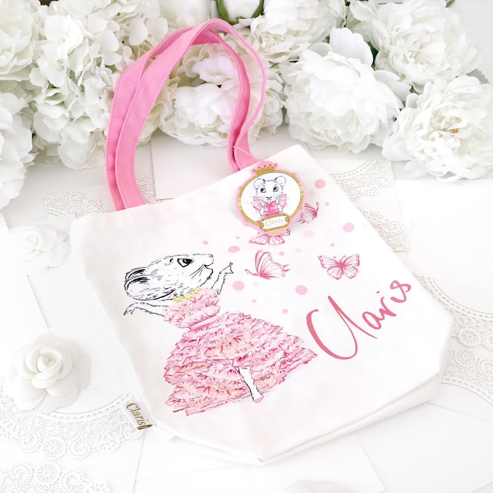 Claris tote bag on a white background with white roses at the top