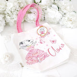 Claris tote bag on a white background with white roses at the top