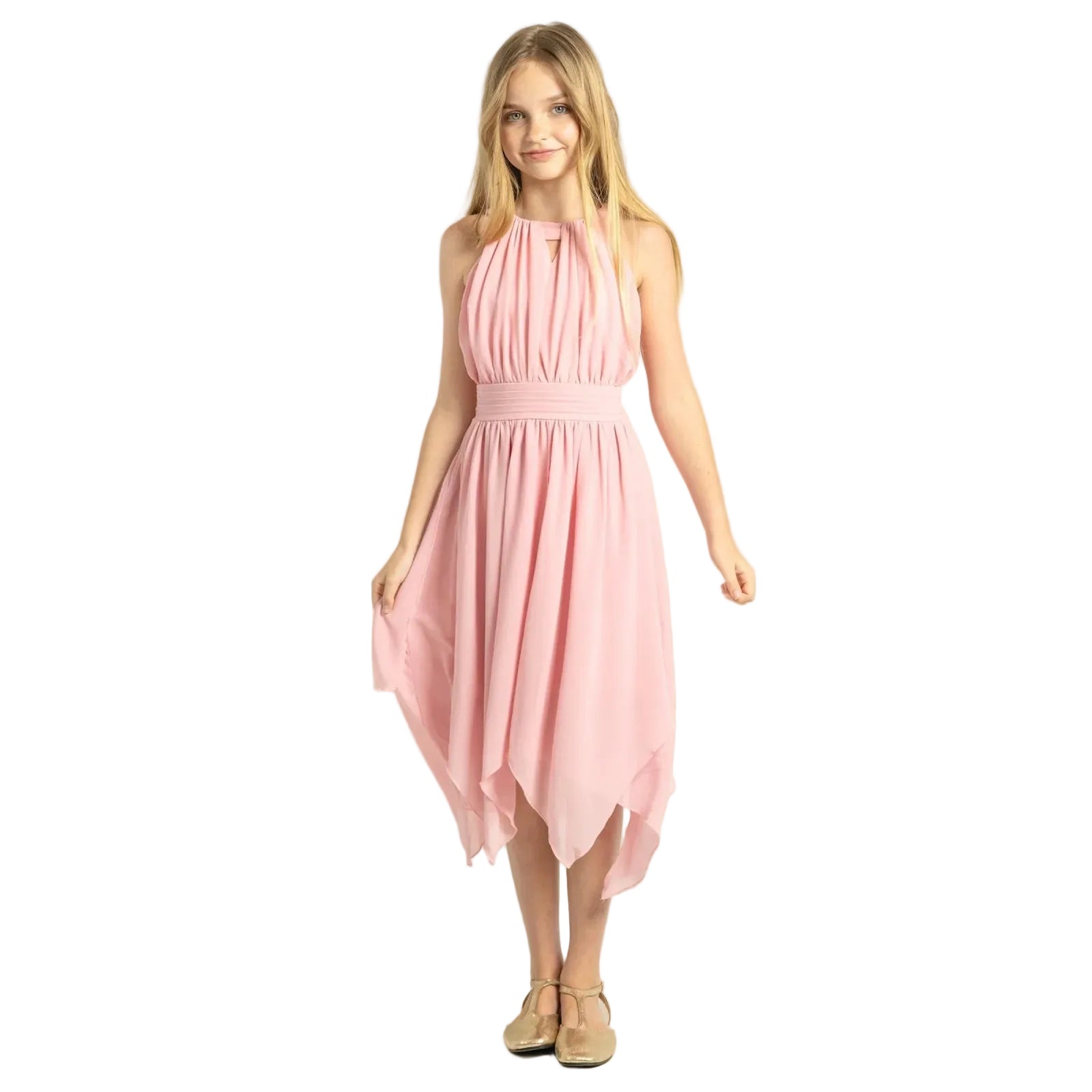 A young girl modeling a light pink sleeveless halter midi dress with a pleated bodice and flowing skirt, paired with beige flat shoes, against a solid beige studio background.