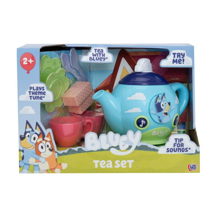 Bluey-themed tea set in its retail packaging, featuring a light blue teapot with Bluey character graphics, a pink cup, and tea accessories visible through the clear window.