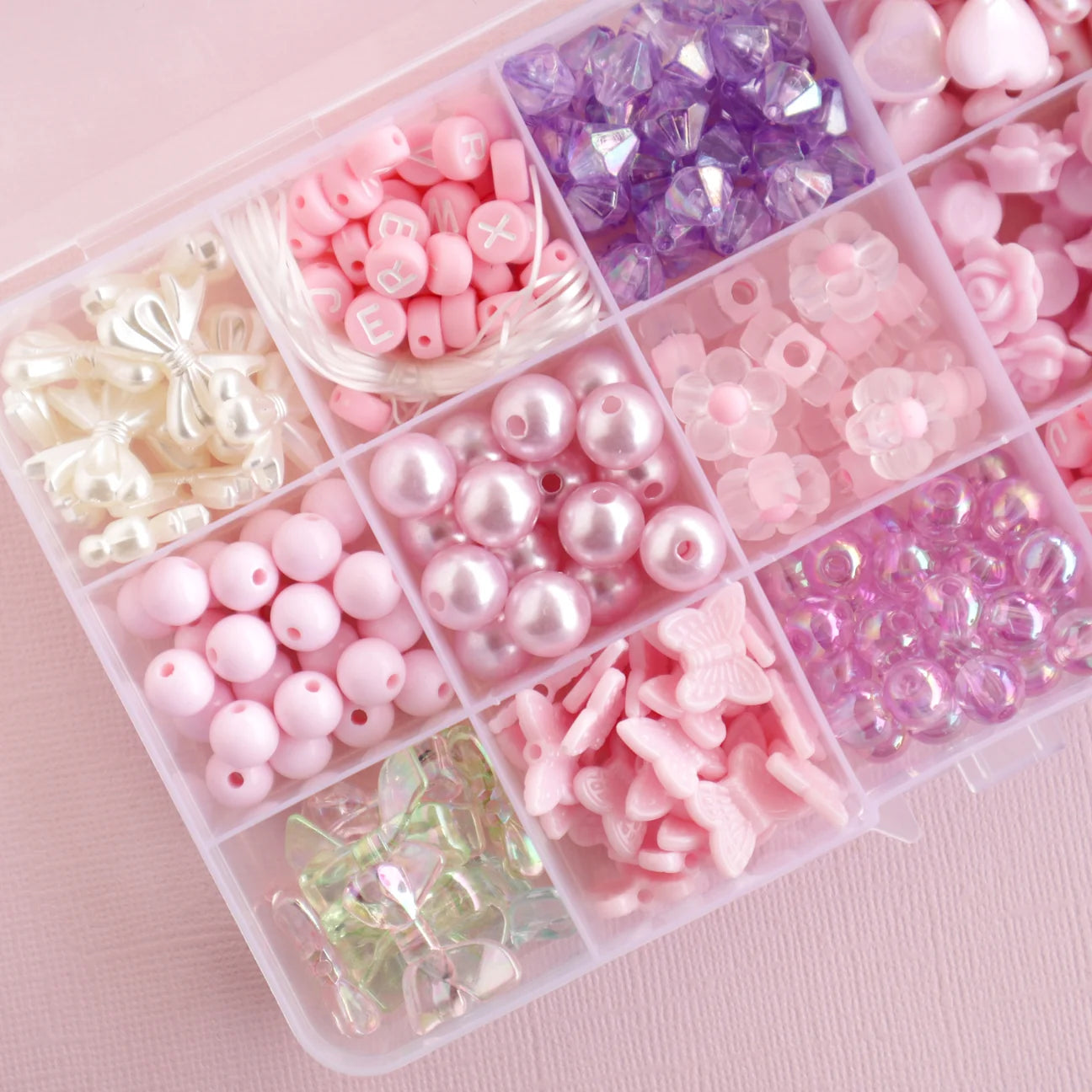 Bead kit packaging with pink and purple beads on a pink background, featuring the brand 'lauren hinkley'.
