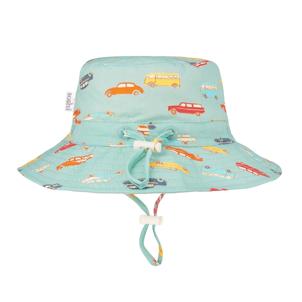 Children's sun hat with a broad brim featuring a colorful wagon wheel pattern on a light blue background, with a head tie for adjustable sizing.