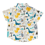 A short-sleeve button-up shirt for kids, featuring an all-over cartoon dinosaur print in yellow, blue, gray, and beige on an off-white background.