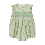 A light green baby romper with a pink green and white floral print, featuring ruffled cap sleeves and a smocked bodice, laid flat against a light gray background. 