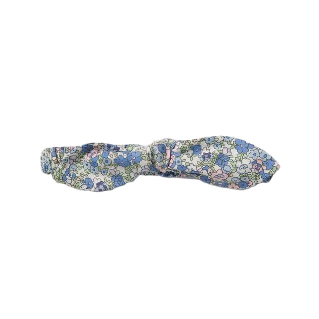 A fabric headband with a dense blue, pink, and white floral print, photographed flat against a neutral light gray background.