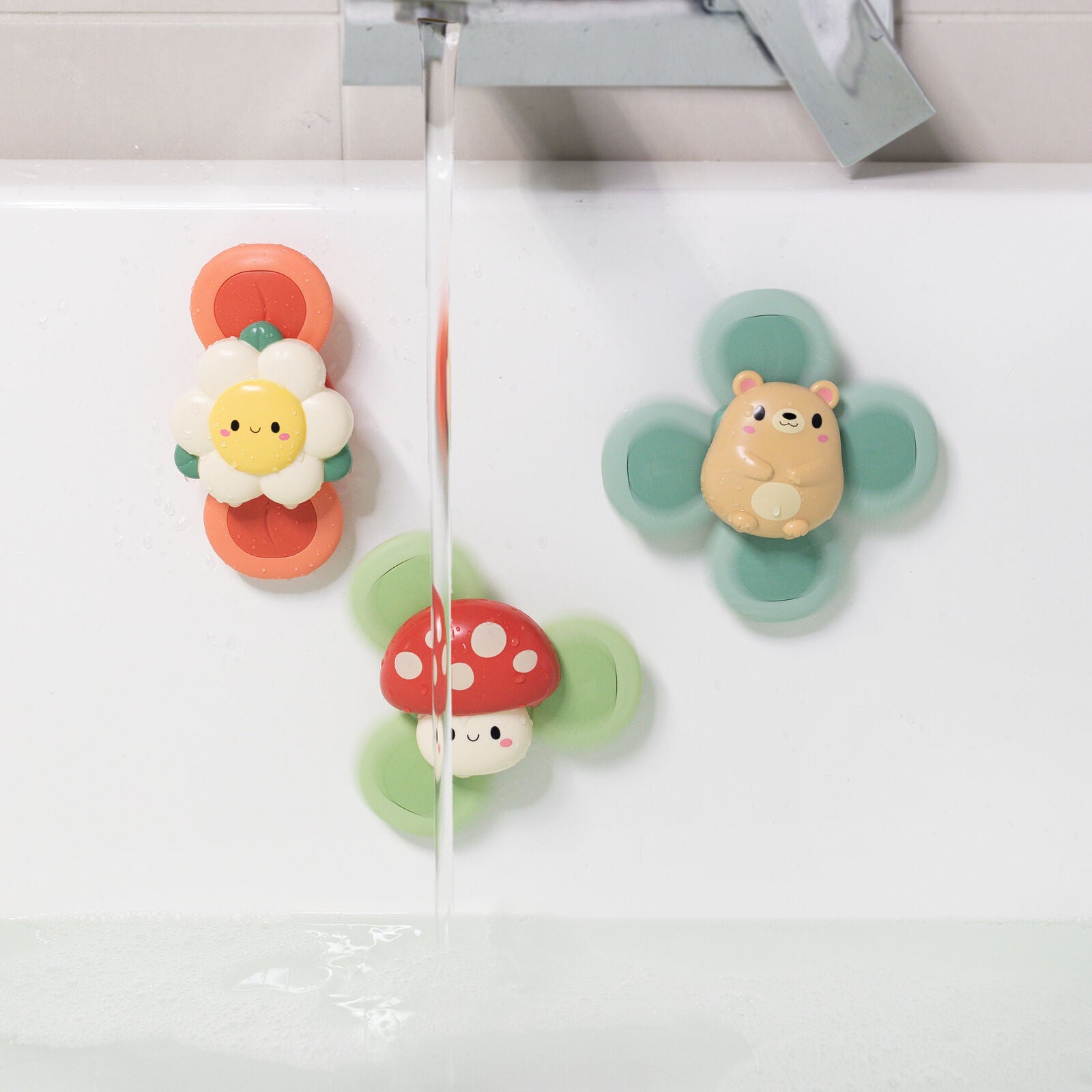 Set of colorful children's toy spinners shaped like a mushroom, flower, and animal on a white background