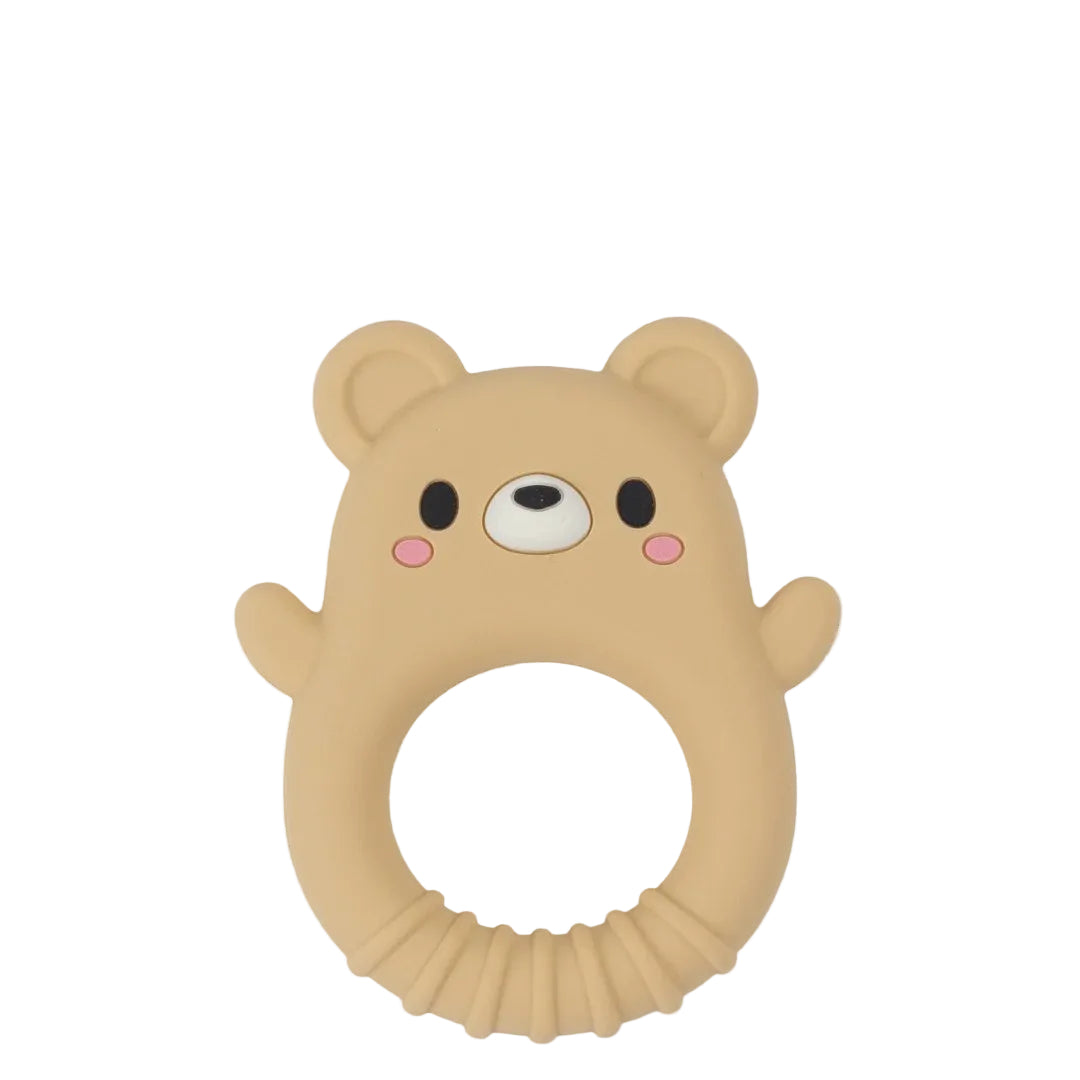 A beige silicone baby teether shaped like a bear face with a circular ring handle, featuring black eyes, a white snout, and pink cheeks, shown on a light gray background.