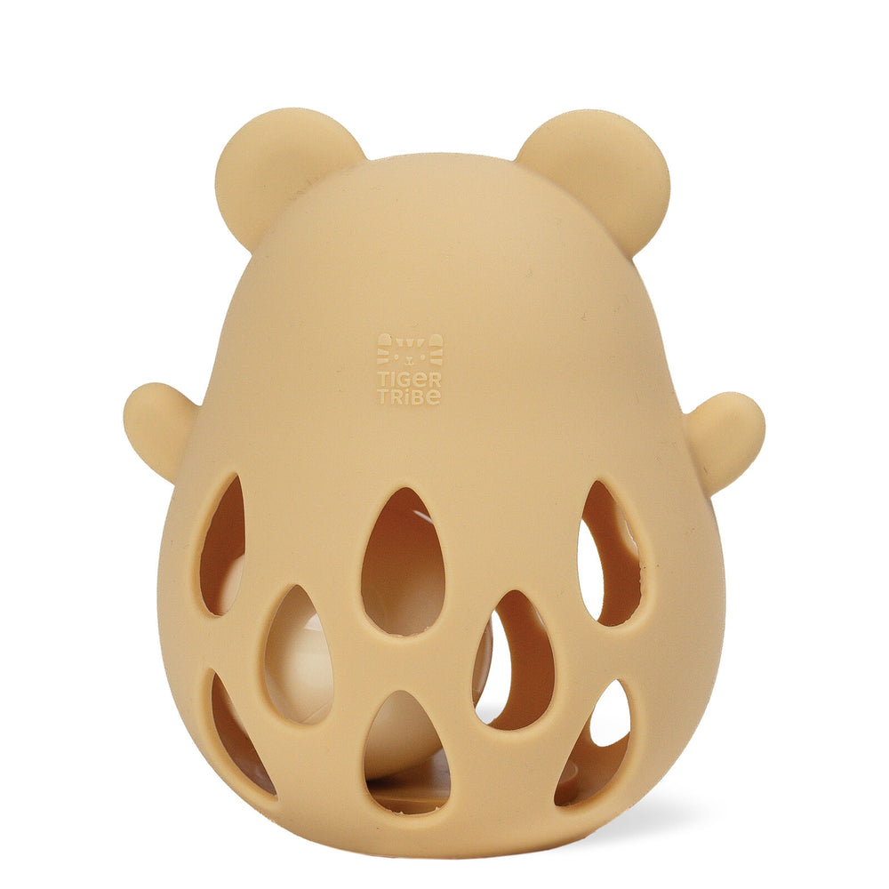 A beige silicone baby teether with a bear head silhouette, featuring ear shapes, side lugs, and cutout teardrop patterns on the front, shown on a white background.