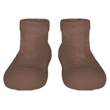 Pair of brown sock shoes on a light gray background