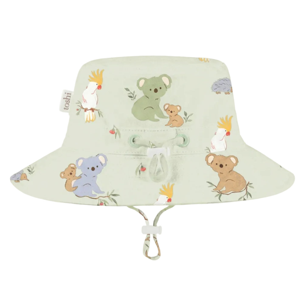 A light sage green  kids sun hat with a drawstring and chin strap, featuring a cute cartoon animal print of koalas, a kangaroo, and cockatoos, shown against a plain light gray background.