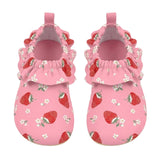 A pair of pink baby mule style swim shoes with a strawberry and white flower print, featuring ruffled trim around the open back and pull tabs, shown on a light gray background.