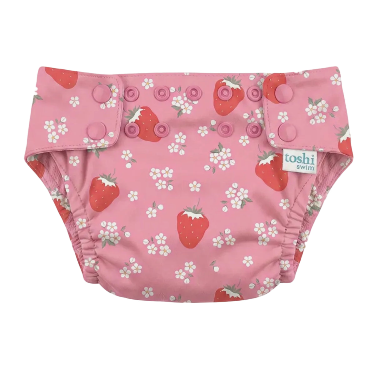 A pink reusable cloth swim nappy with a strawberry and white flower print, featuring three snap closures on the front and a visible 'toshi' brand tag.