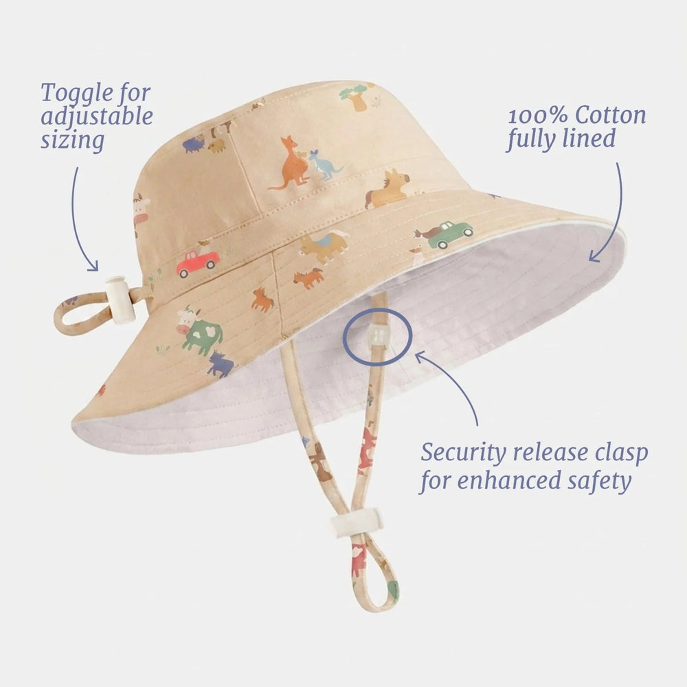 A beige cotton sun hat with a colorful animal print, featuring text callouts highlighting its adjustable toggle, fully lined interior, and safety release clasp on a light gray background.