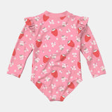 A pink long-sleeve baby bodysuit with a strawberry and white flower print, featuring ruffled shoulder details, shown flat on a light gray background.