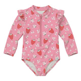 A pink long-sleeve baby swimsuit with a front zipper, ruffled shoulder details, and an all-over strawberry and white flower print, shown against a solid light gray background.