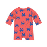 A coral orange long-sleeve baby swim onesie with a blue crab pattern, shown flat against a light gray background.