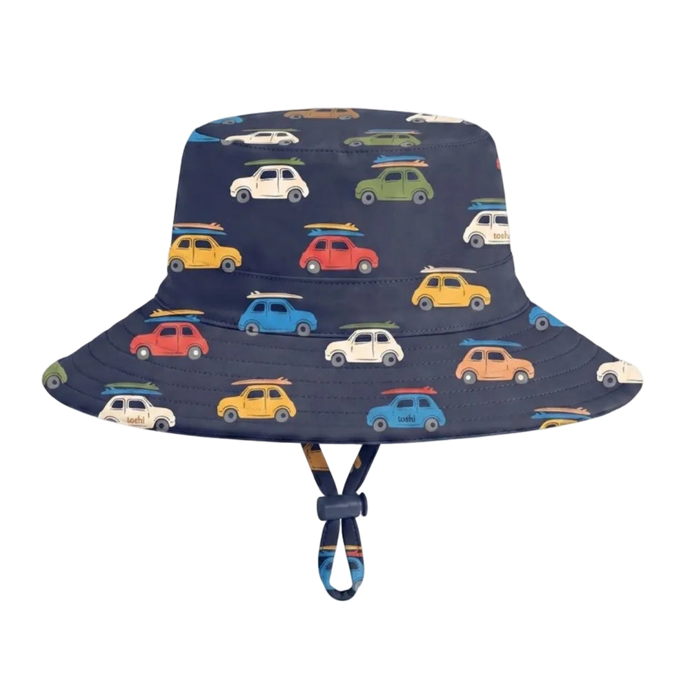 A navy blue swim bucket hat with an all-over pattern of colorful vintage cars in yellow, red, green, blue, and white. The hat features a chin strap with a striped fabric accent.