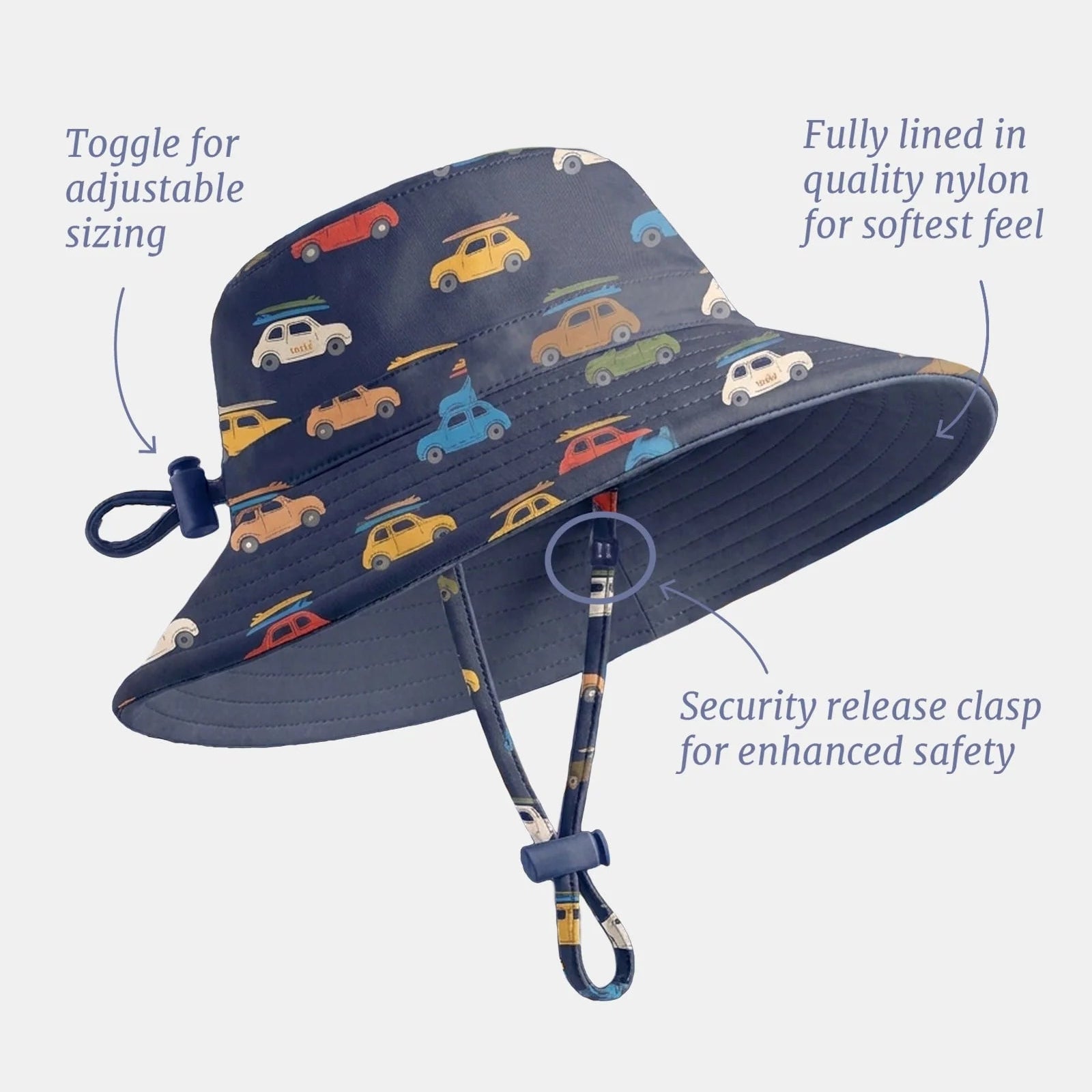 A navy blue swim hat with a colorful vintage car pattern, shown with callout lines and text explaining features like adjustable sizing, fully lined nylon, and a security release clasp, on a light gray background.
