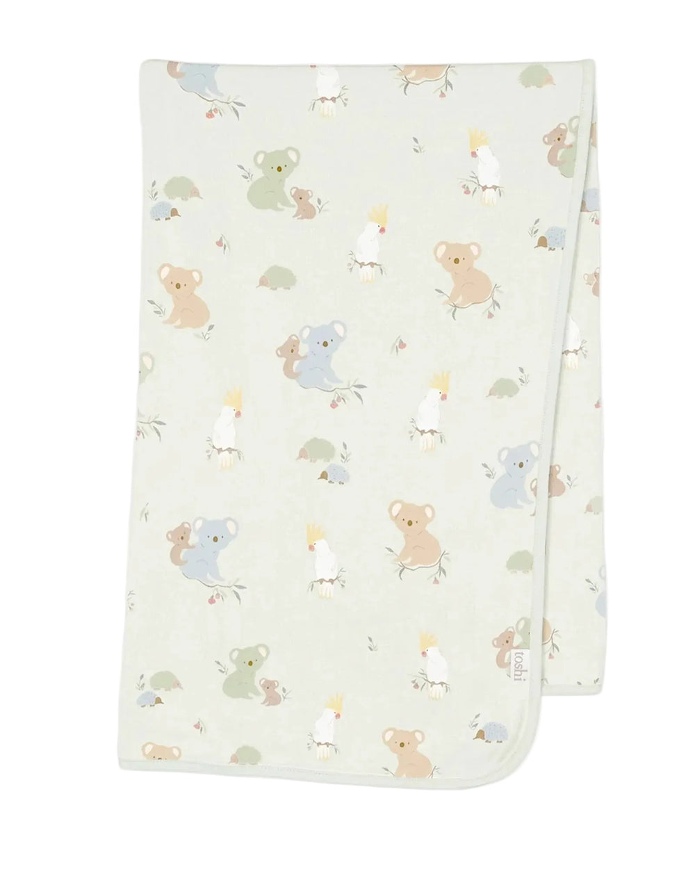 A folded knit baby blanket with a light sage green background and a playful pattern of cartoon koalas, kangaroo babies, and birds in soft pastel colors, shown on a neutral light gray background.
