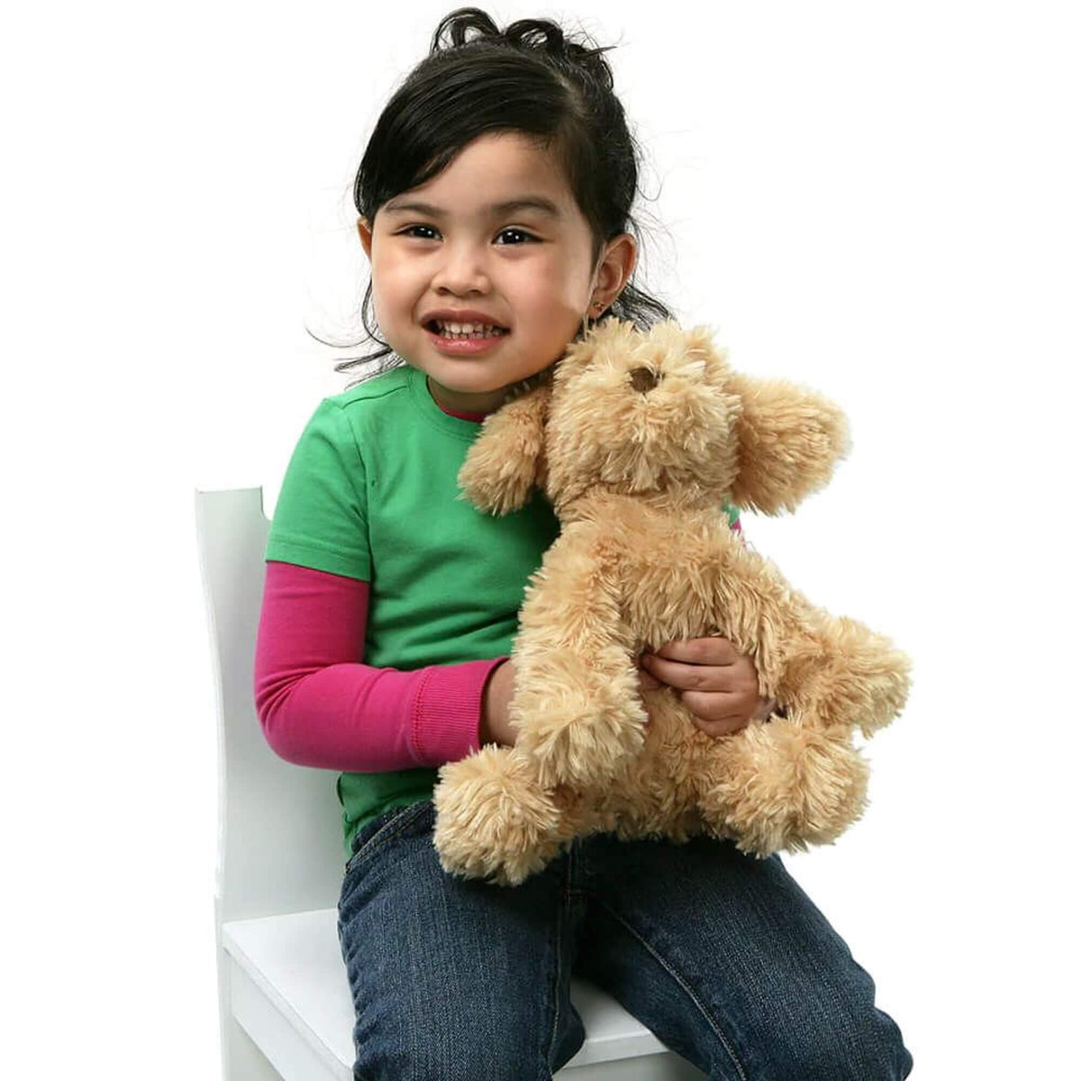 Toy plush cavoodle dog with girl sitting on a white chair