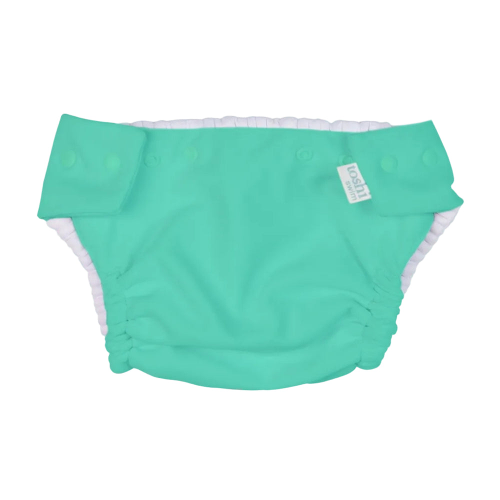 Green swim diaper with UPF 50+ sun safety label on a white background
